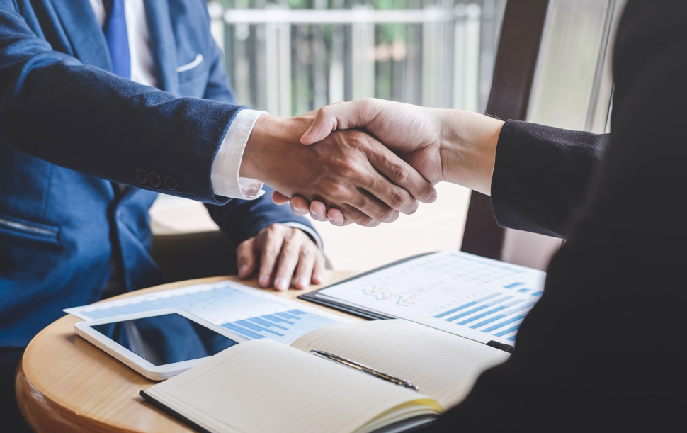 Finishing up a meeting, handshake of two happy business people after contract agreement to become a partner, collaborative teamwork.